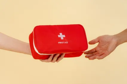person handing someone a first aid kit 