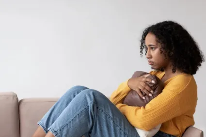 Person clutching pillow looking sad 