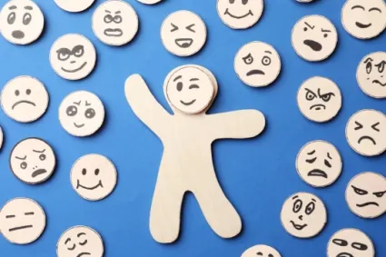paper cut out faces making different expressions surrounding a paper guy