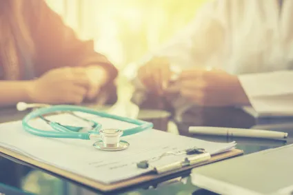 Photo of arms of clinician and patient having a discussion