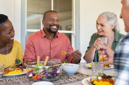 Photo of group of adults having dinner outside