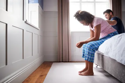 Photo of a man comforting a woman in pajamas