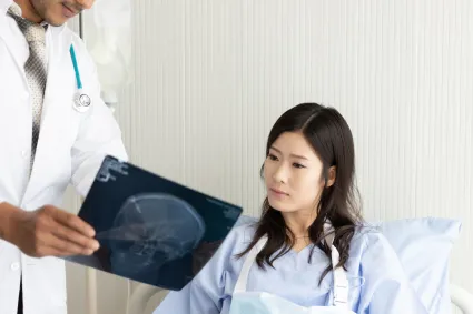 Photo of individual with TBI looking at brain imaging with clinician