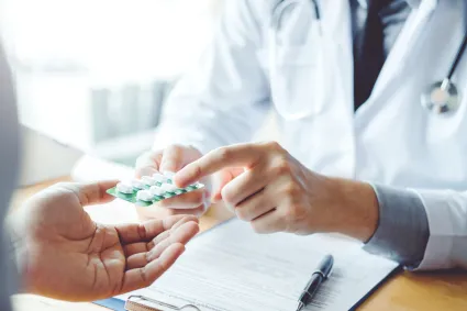 Photo of clinician handing a patient medication