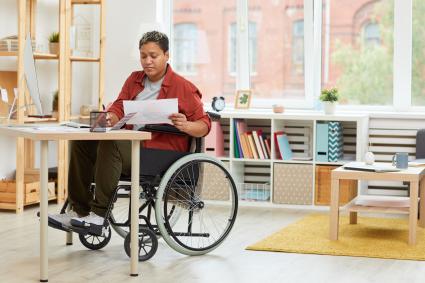 Photo of woman in wheelchair sitting at a desk