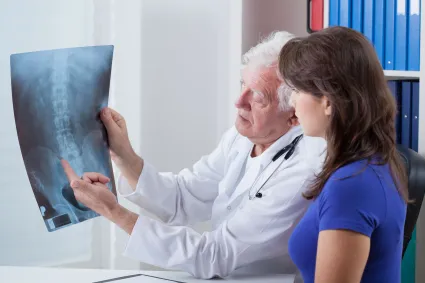 Photo of clinician looking at Xray with individual with SCI