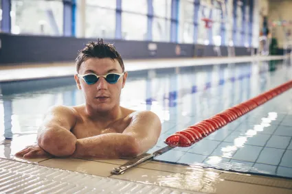 Photo of a young male with an amputated arm at a swimming pool