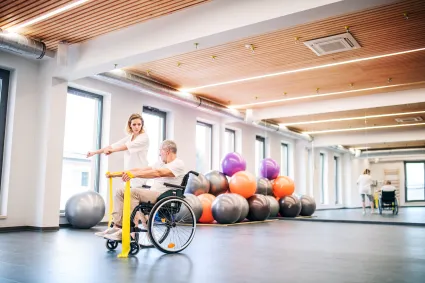 Photo of individual with SCI doing physical therapy with clinician