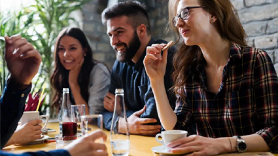 Un grupo de amigos riendo y pasando el rato en una cafetería