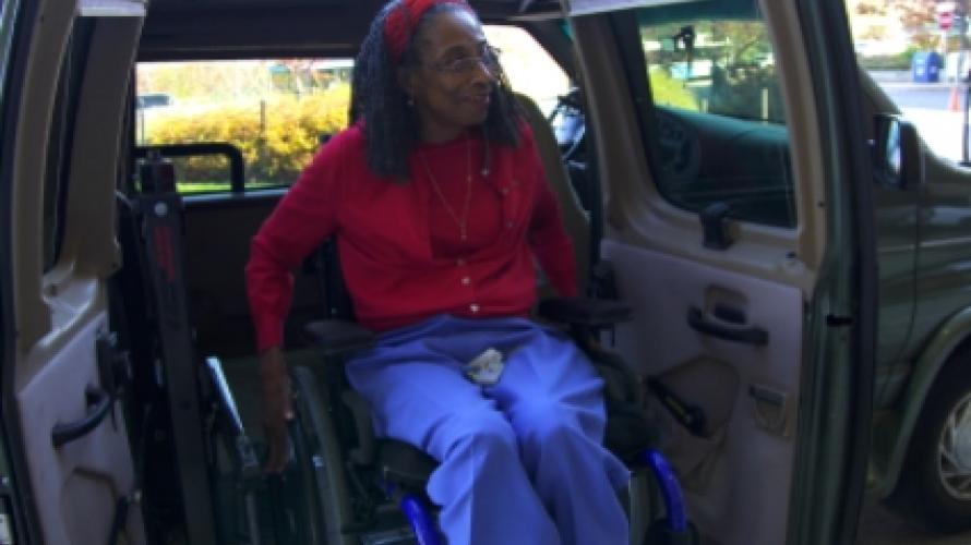 Mujer mayor en silla de ruedas saliendo de la camioneta
