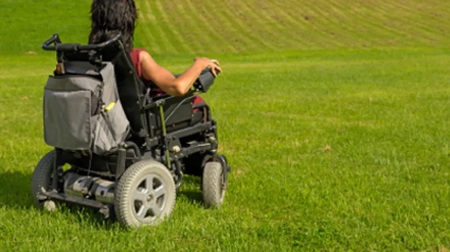 Woman on a wheelchair in a large field