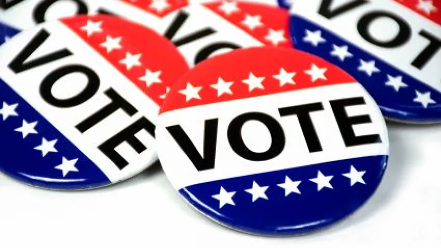circular red and white buttons with stars drawn and "vote" written on it 