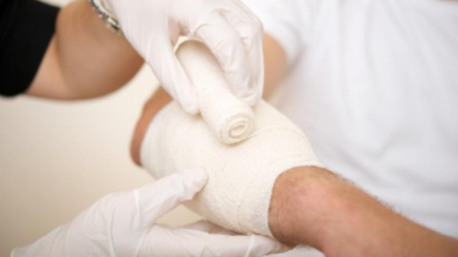Clinician bandaging hand