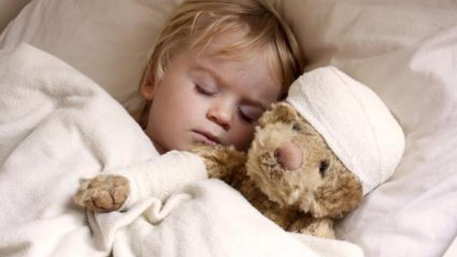 Child sleeping next to a teddy bear