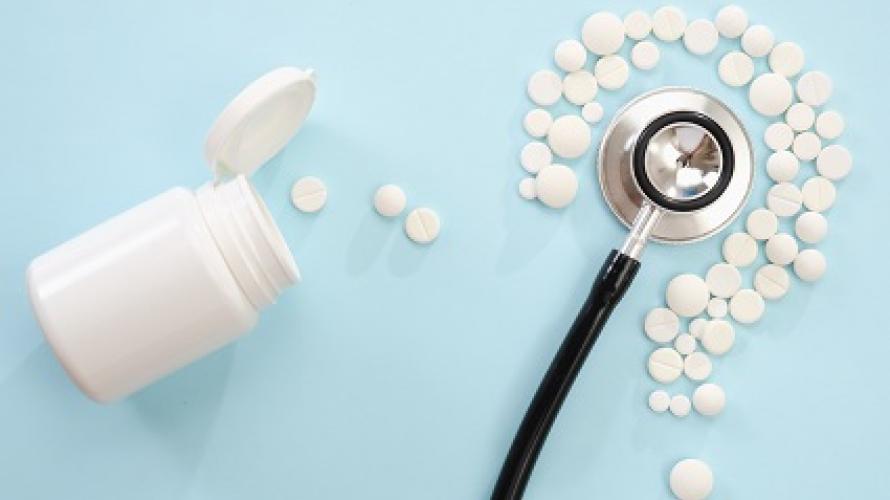 Pills and stethoscope on a light blue background
