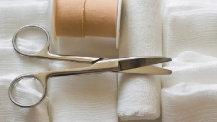 Gauze and scissors on plain background