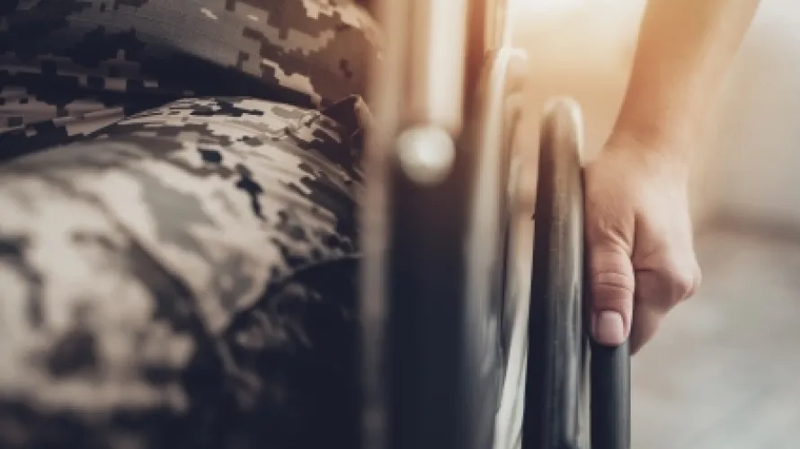 Person in military uniform sitting in a wheelchair.