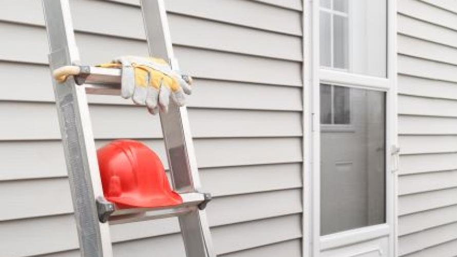 Ladder and hard hat leaning against a wall