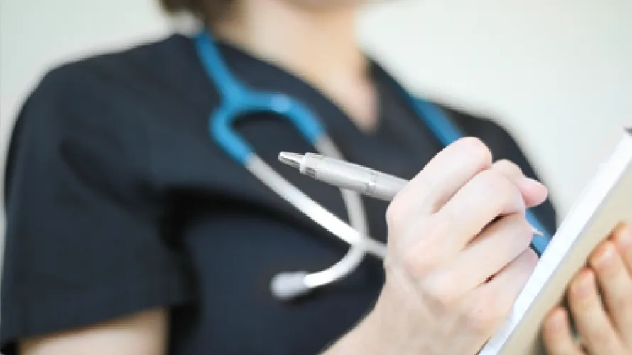Doctor writing on note pad