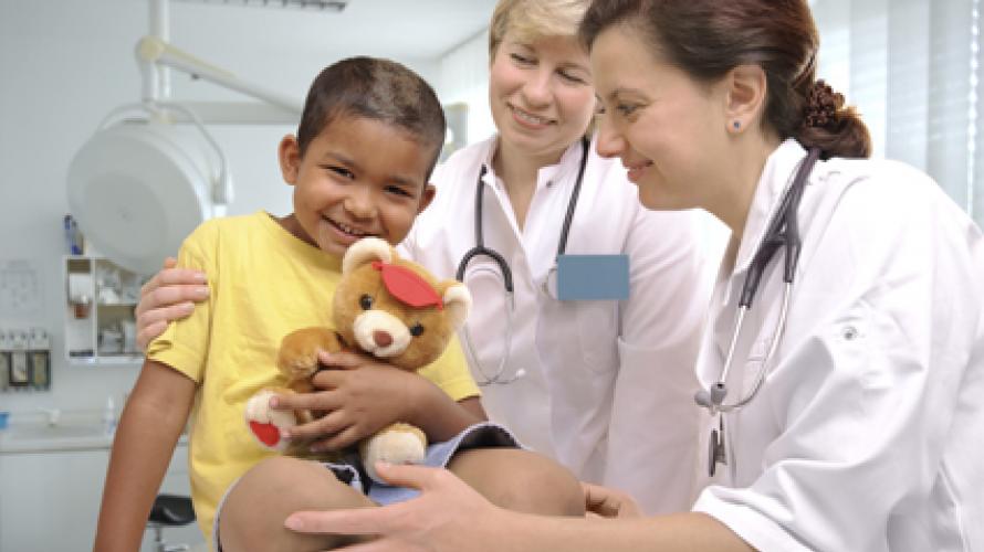 Doctor giving teddy bear to child 
