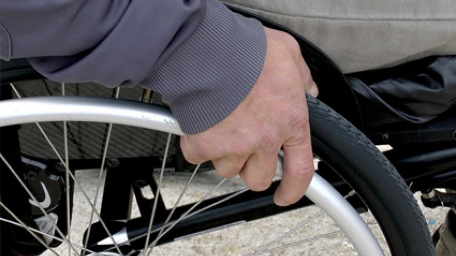 Person's hand on wheel of wheelchair