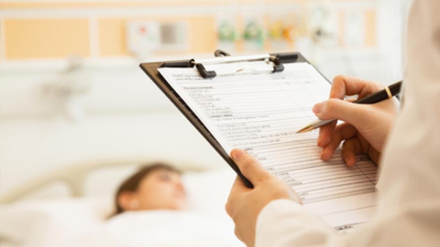 Doctor making notes in patient's chart