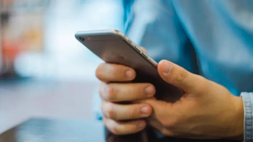 Person holding phone utilizing telehealth intervention