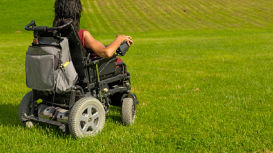 Person using power wheelchair in a grass field