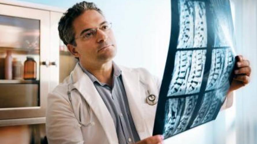 Doctor looking at spinal cord x-ray