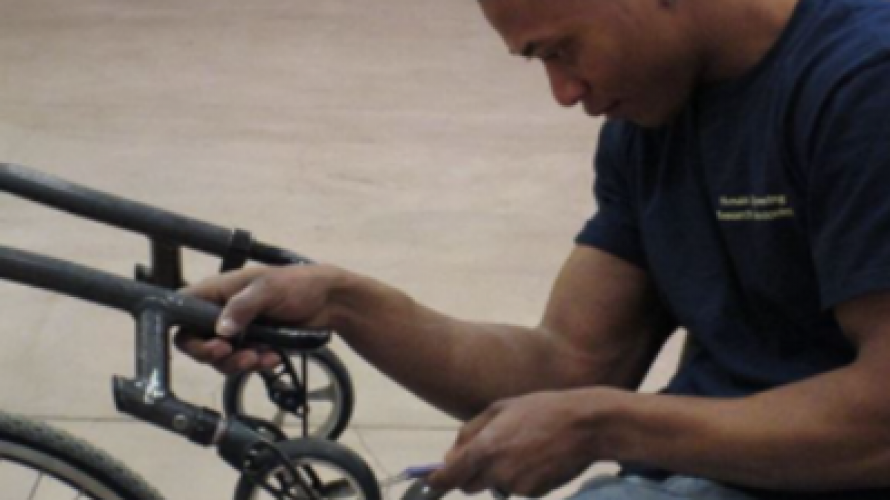 Man making repairs to manual wheelchair