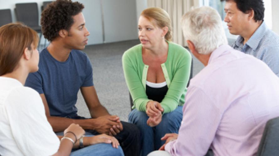 A support group of five people sitting and talking
