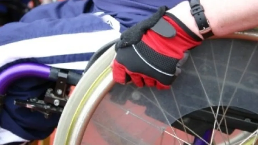 Man in wheelchair wearing red glove