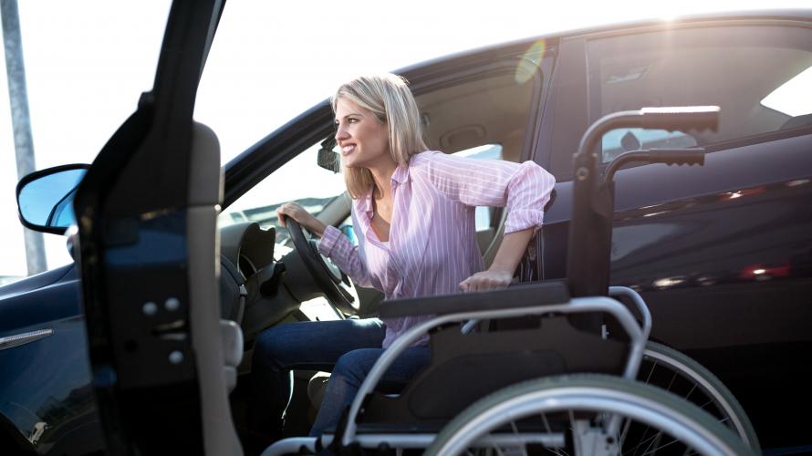 Photo of woman transferring from wheelchair to vehicle