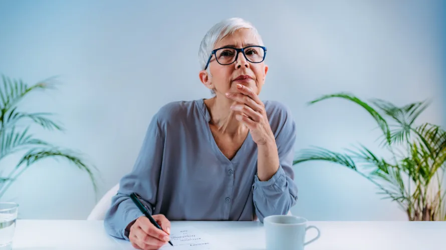 A woman thinking while writing